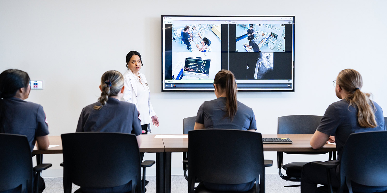 Nursing instructor talking to students in a classroom