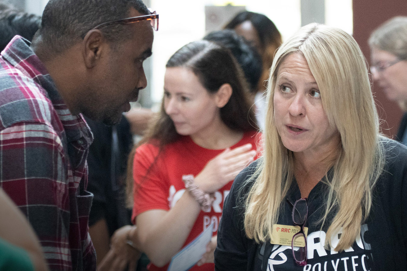 Two people speaking at a busy orientation event