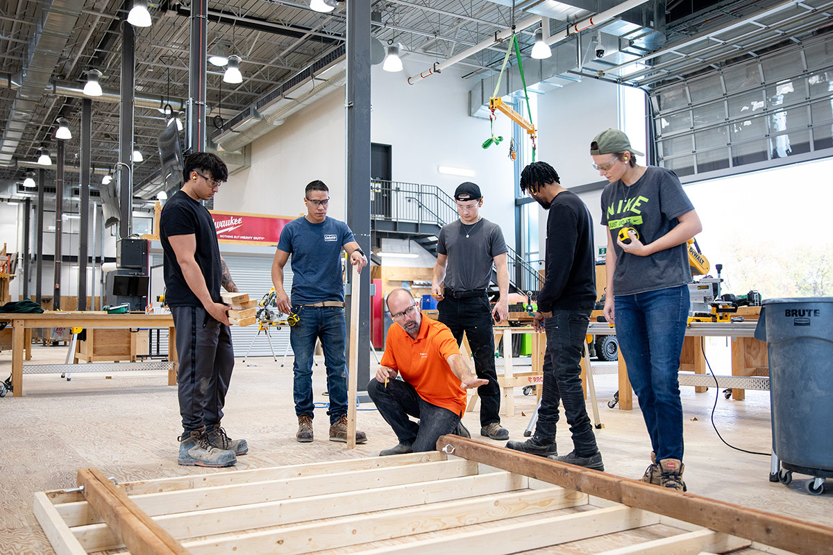 Instructor showing carpentry students a technique