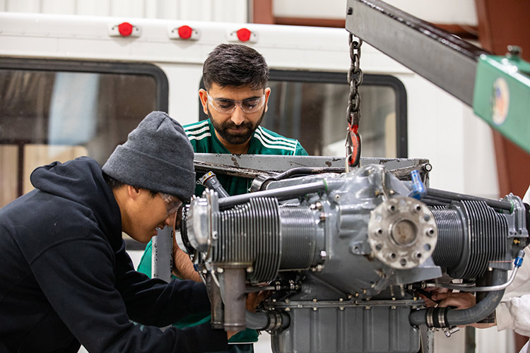 Students in a machine shop working on an engine