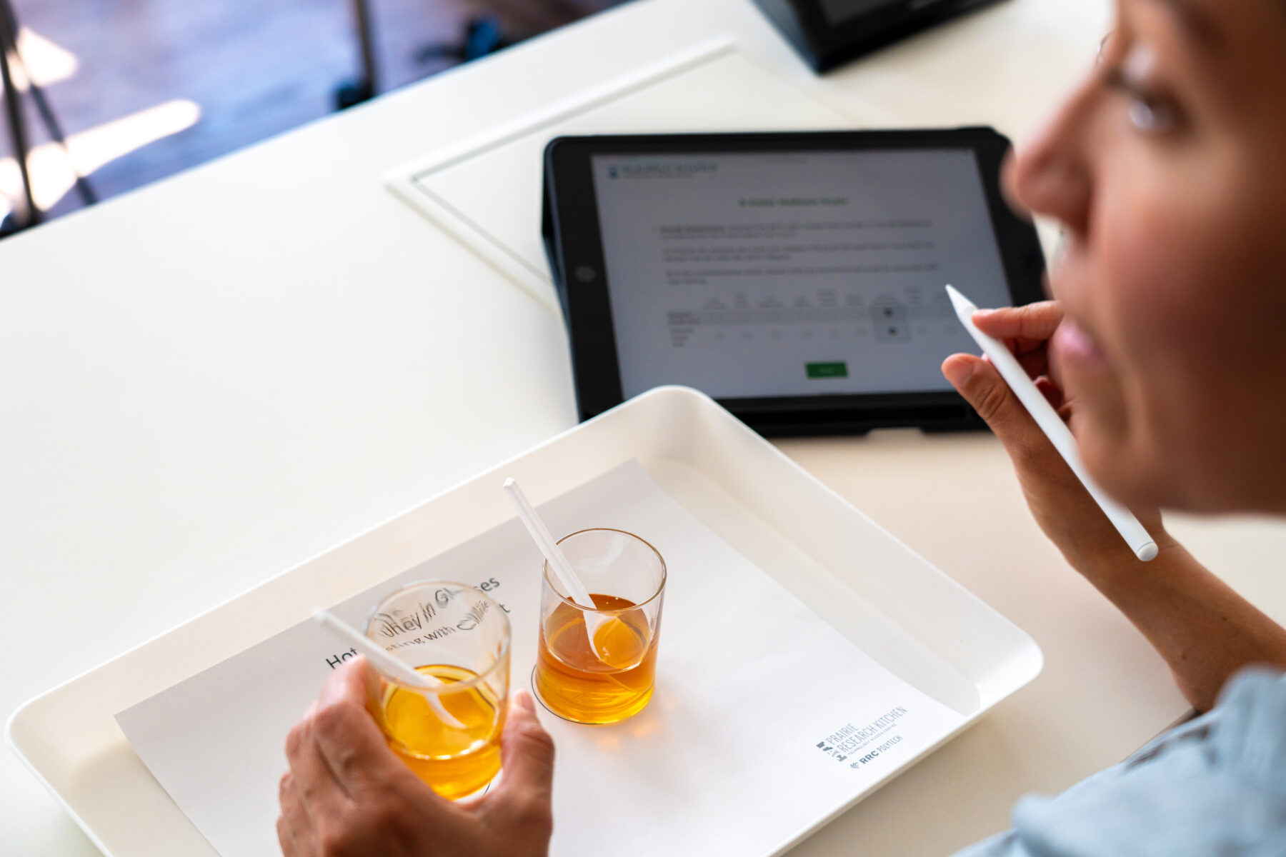 jars of honey samples on a tray next to a tablet