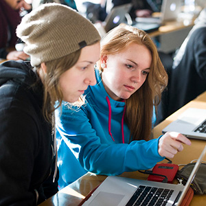 two creative arts students looking at laptop