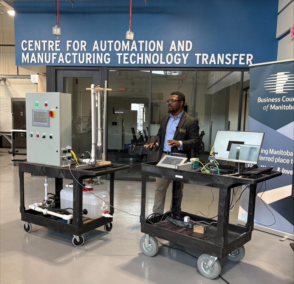 A presenter demonstrates two mechanical items from  applied research projects