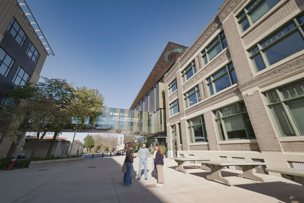 Four students having a conversation at Elgin Plaza on the Exchange District Campus.