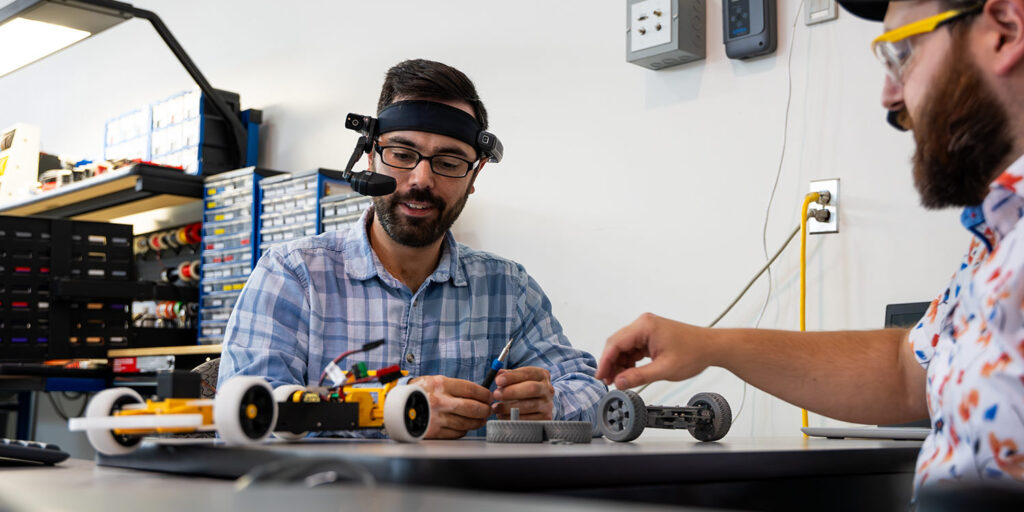 Two people in a lab working with robotics