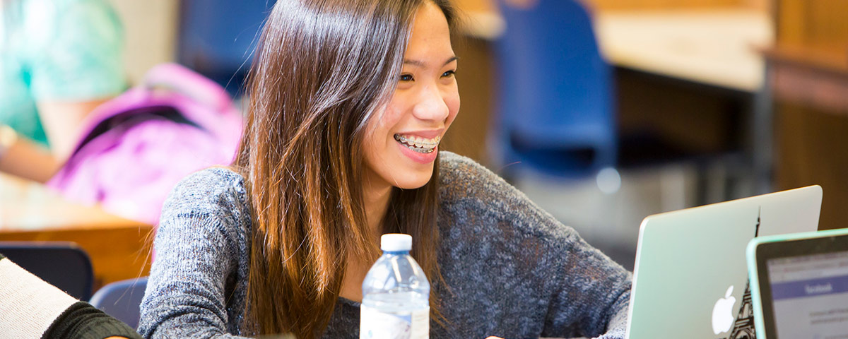 Smiling student working on a laptop