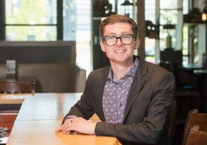 Red River College graduate Chad Corbett sits at a table at the restaurant he co-owns, the Block & Blade Restaurant and Bar.