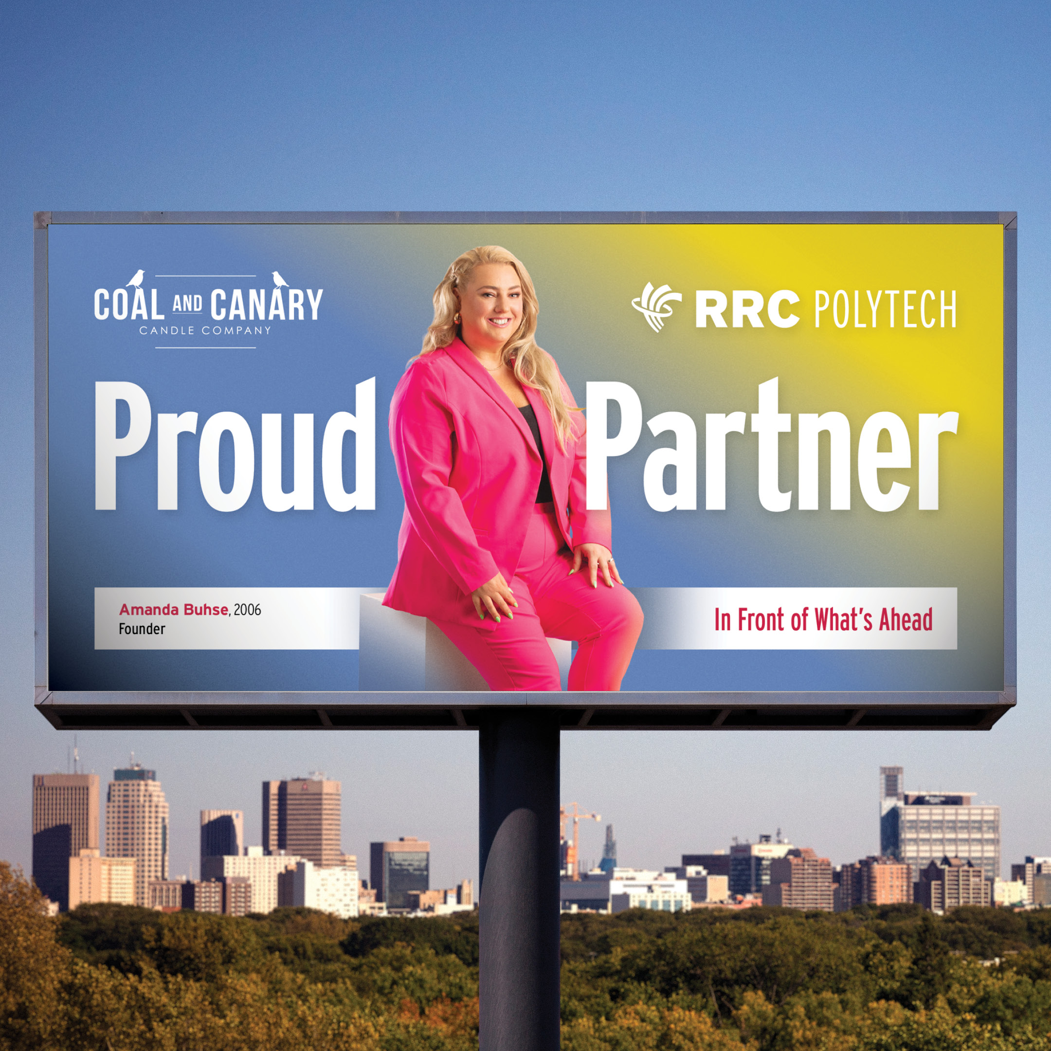 Amanda Buhse pictured in a bright pink suit on her Polytechnic Proud billboard. The billboard also includes logos from RRC Polytech and Coal and Canary. 