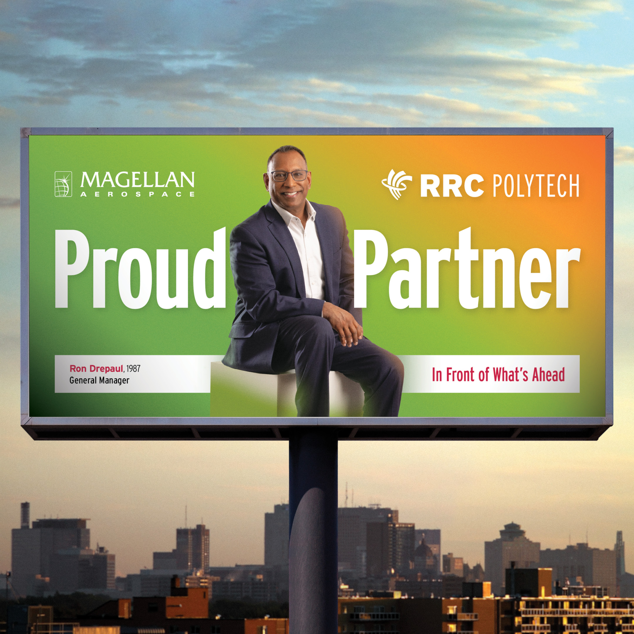 Ron Drepaul in a black suit and white shirt pictured on a RRC Polytech Proud Partner campaign billboard. 