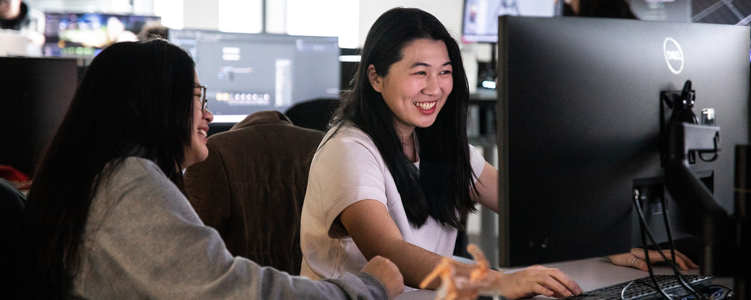 Smiling students working in a computer lab