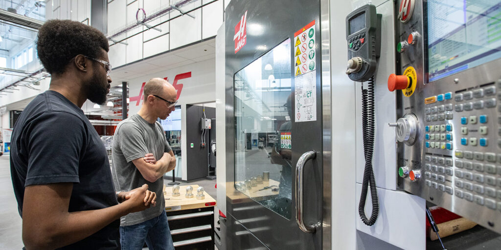 People looking at a machine in a workshop
