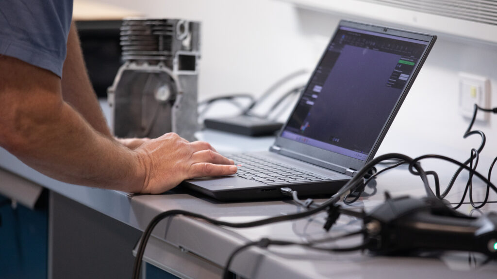 a hand typing on a laptop computer