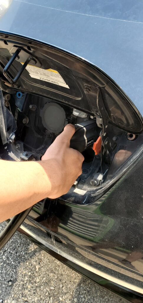 a hand plugs a charger into an EV
