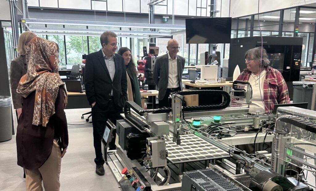 a group of people looking at manufacturing technology in a smart factory