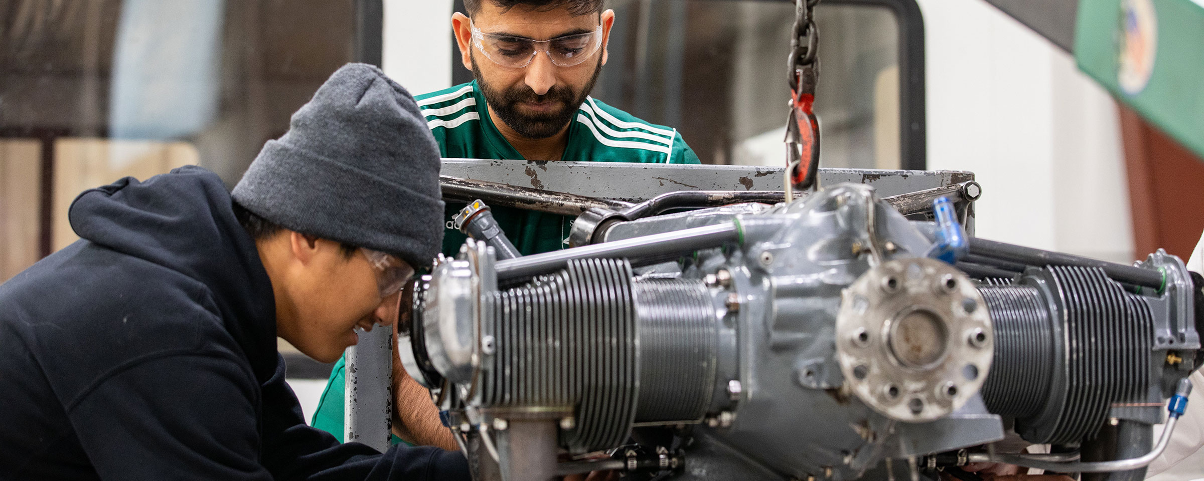 Students in a machine shop working on an engine