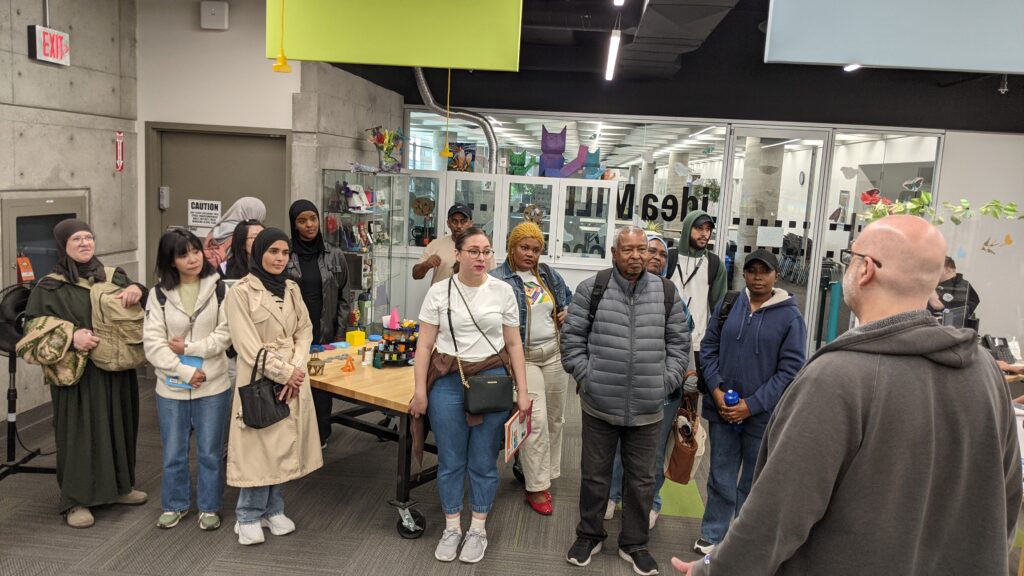 A group of students standing in front A library staff member.