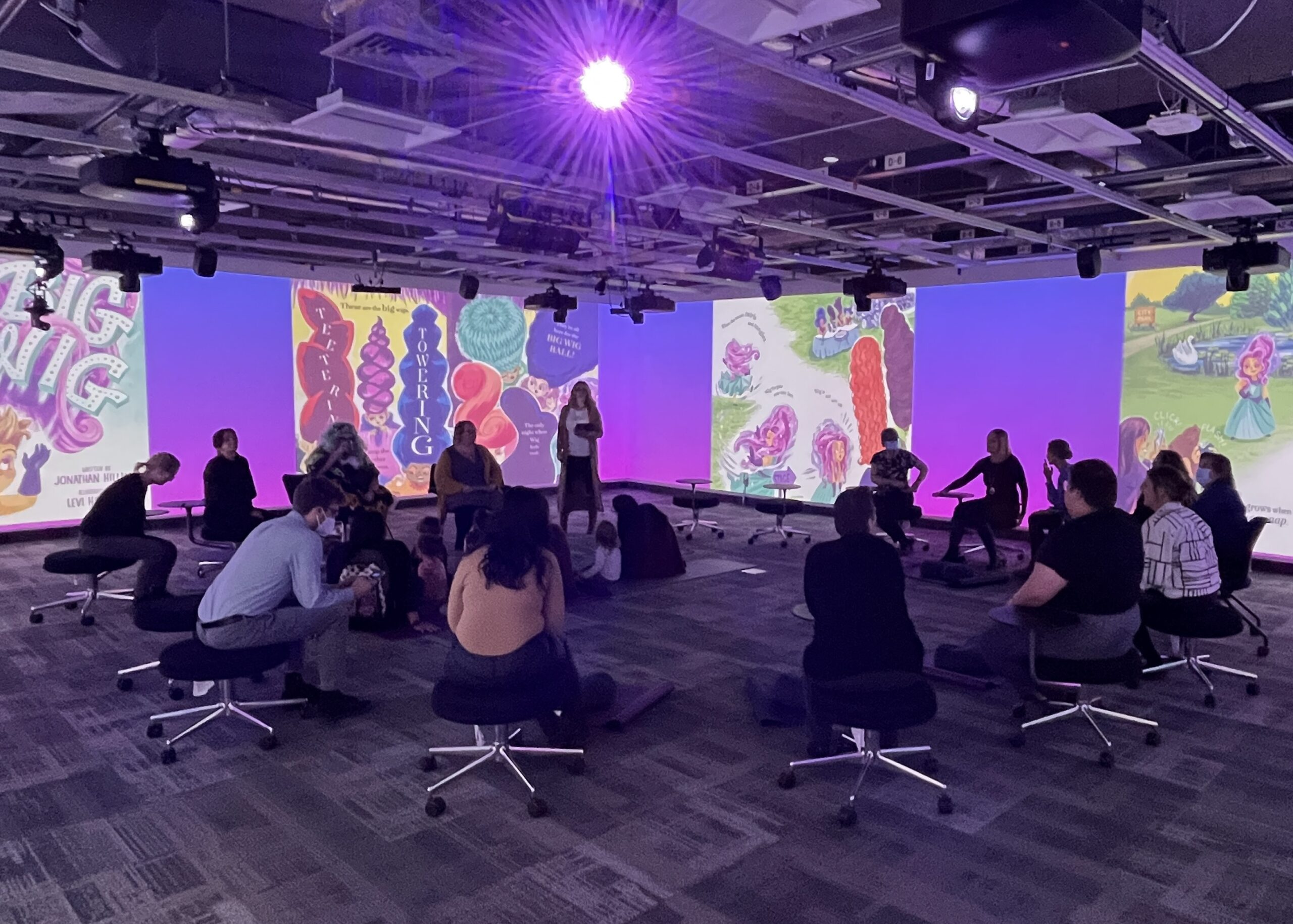 Students gather for a presentation in the Immersion Room, which has 360 projection around the room.