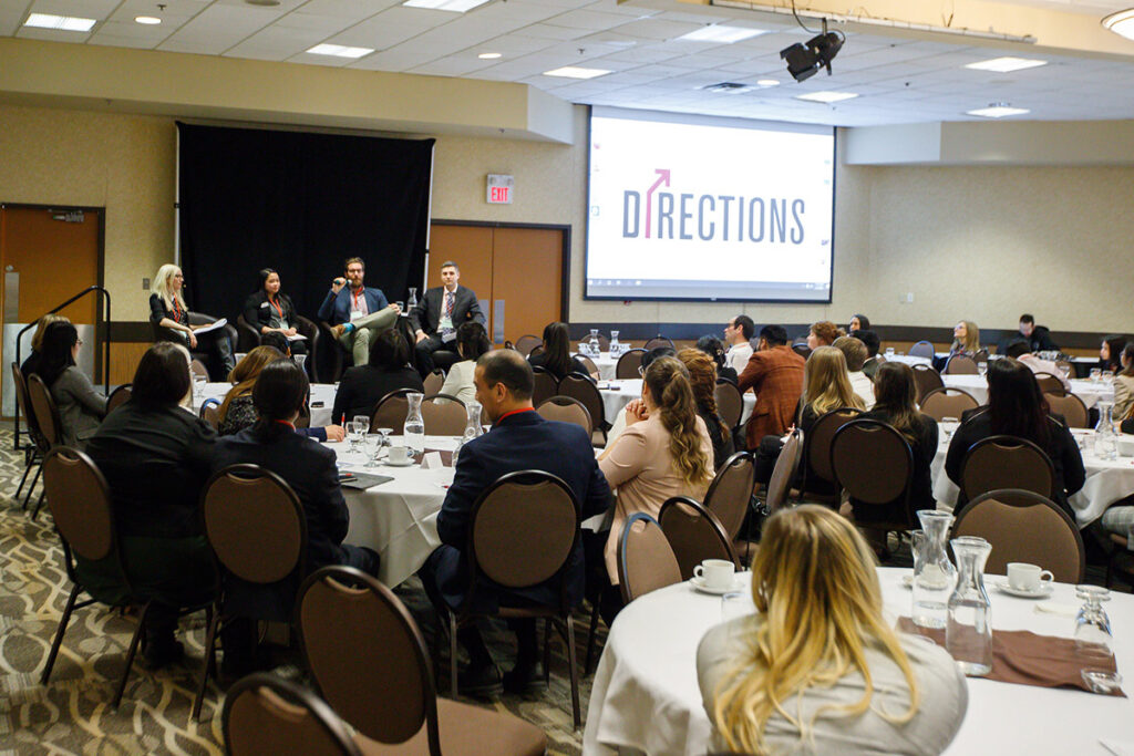 Students sitting at round tables at a business conference