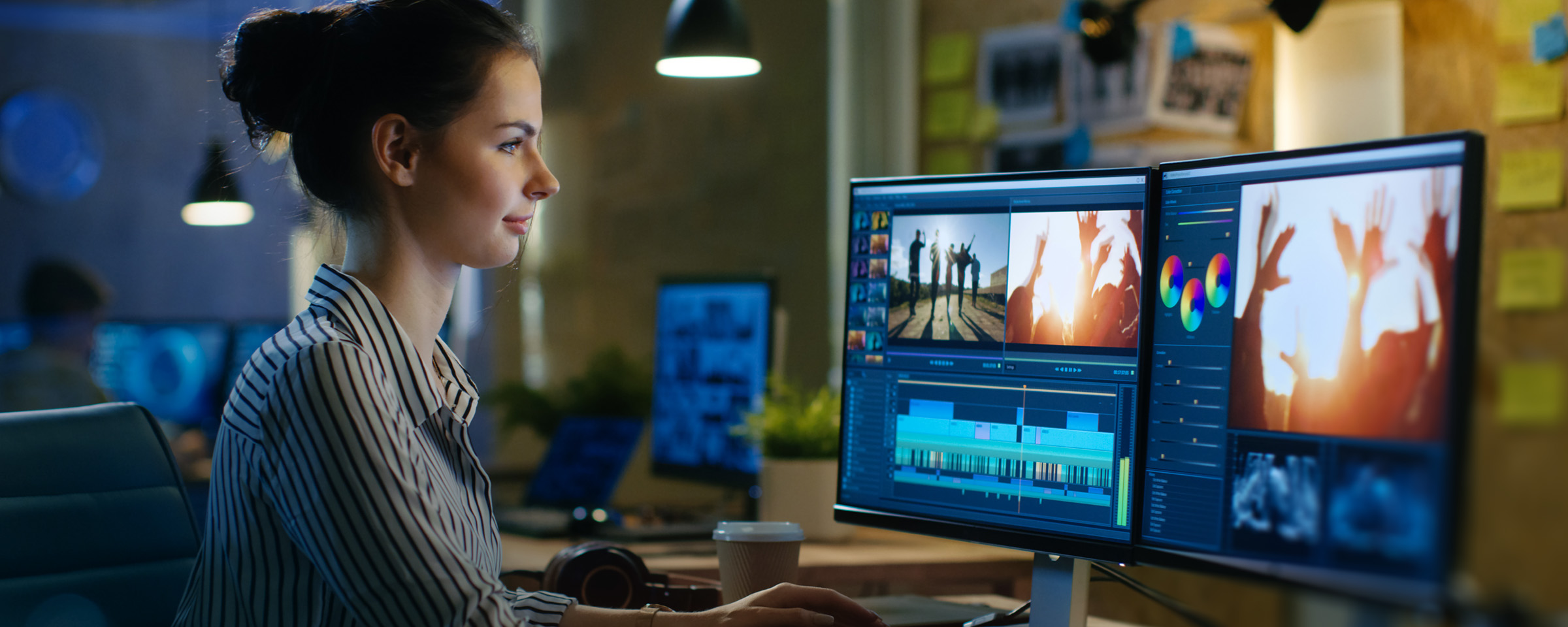 Girl at desk looking at computer monitors