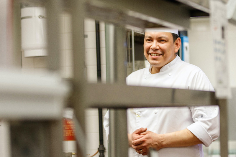 A chef smiling in a kitchen