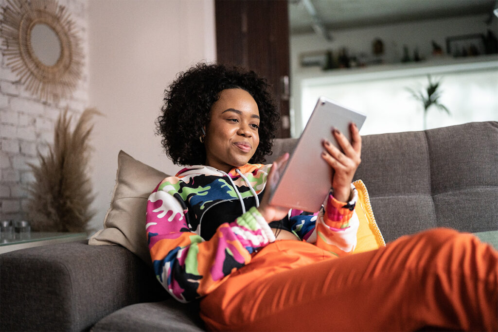 Woman sitting on a couch and looking at a tablet