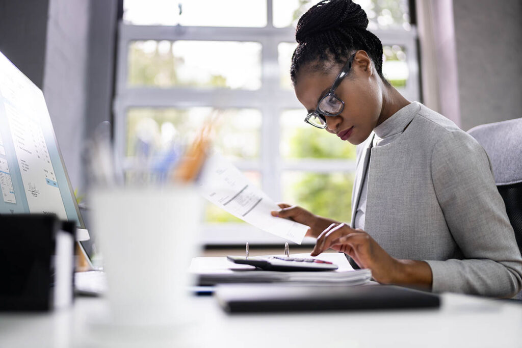 Woman tabulating numbers on a calculator