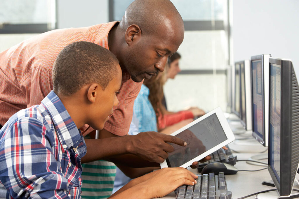 Teacher showing student something on a tablet