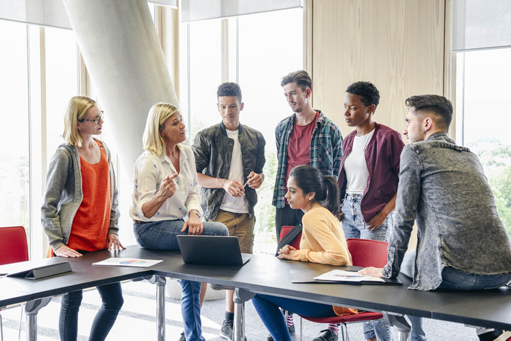 Teacher talking to a group of students in a classroom