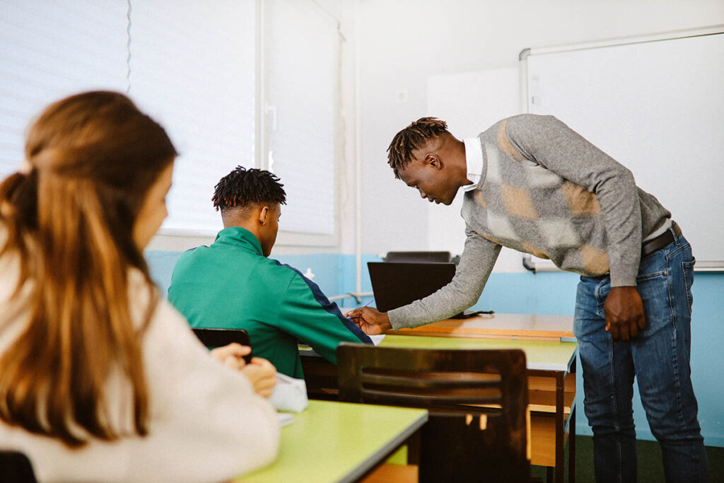 Teacher helping student in a classroom 