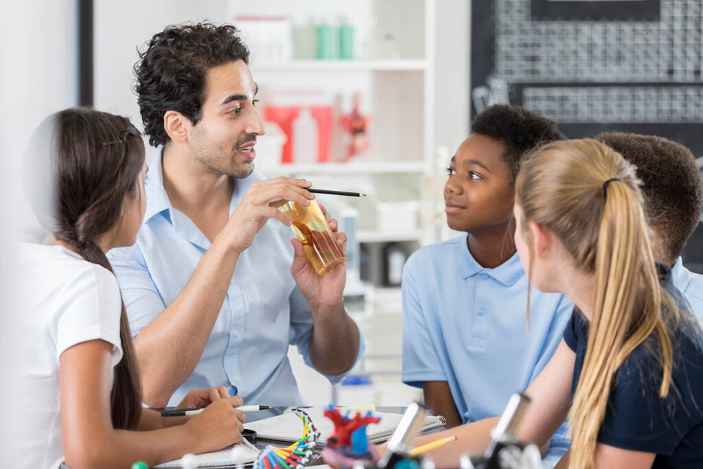 Teacher talking to a group of students in a classroom