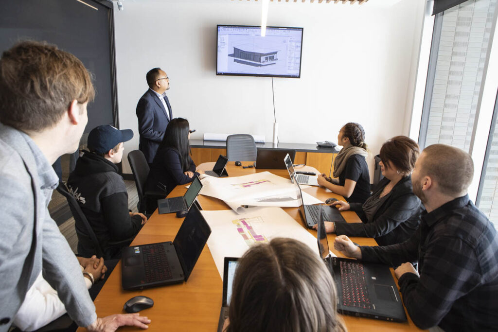 Instructor explaining architectural drawing to students