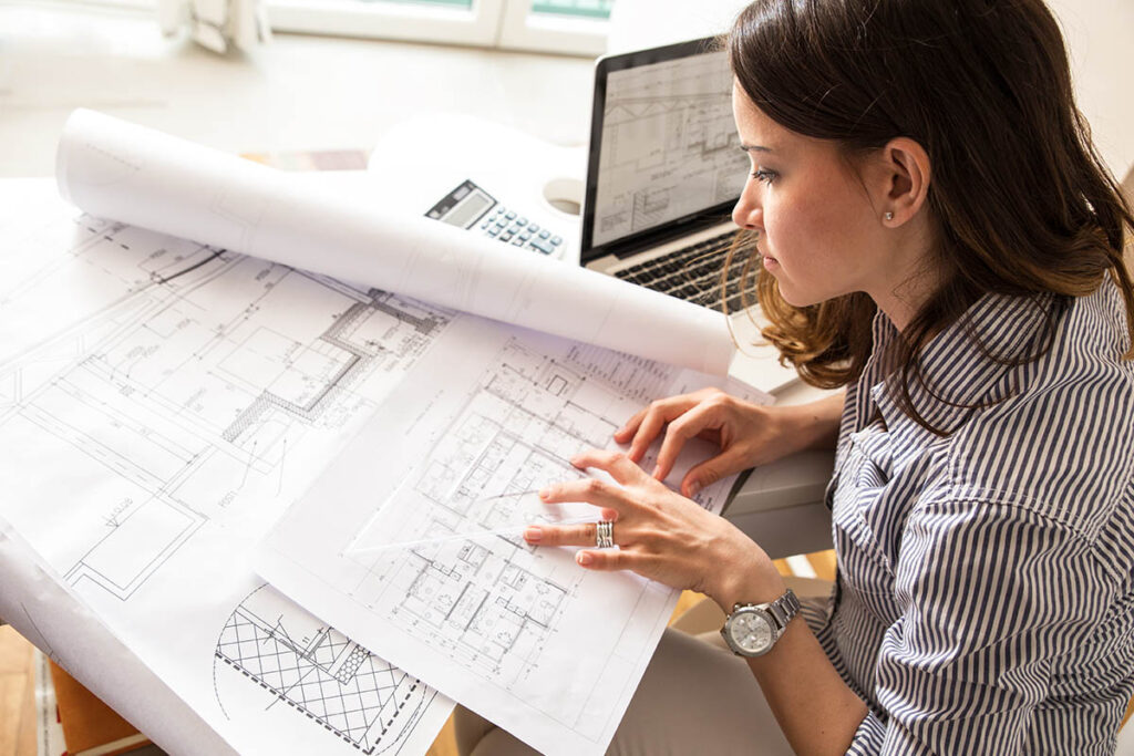 Student looking at blueprints on a desk