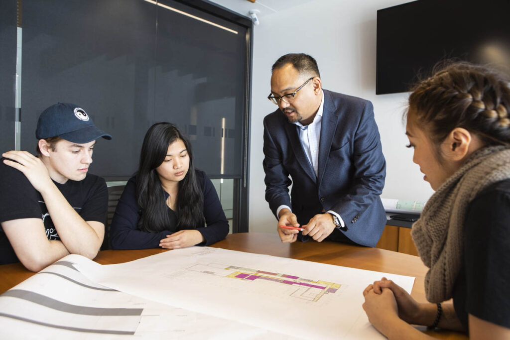 Instructor talking to students in a boardroom