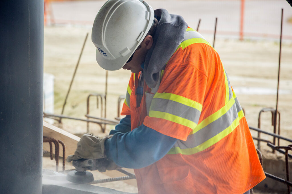 Construction worker grinding material down at a construction site