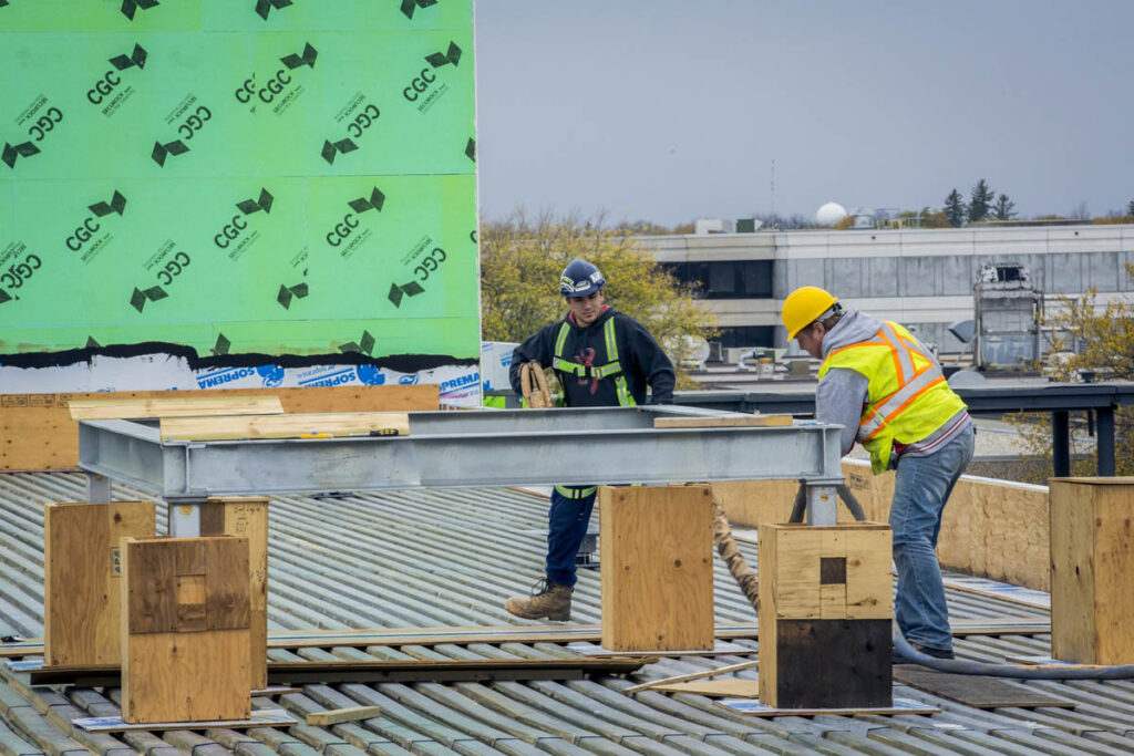 Construction workers at a job site building a metal frame