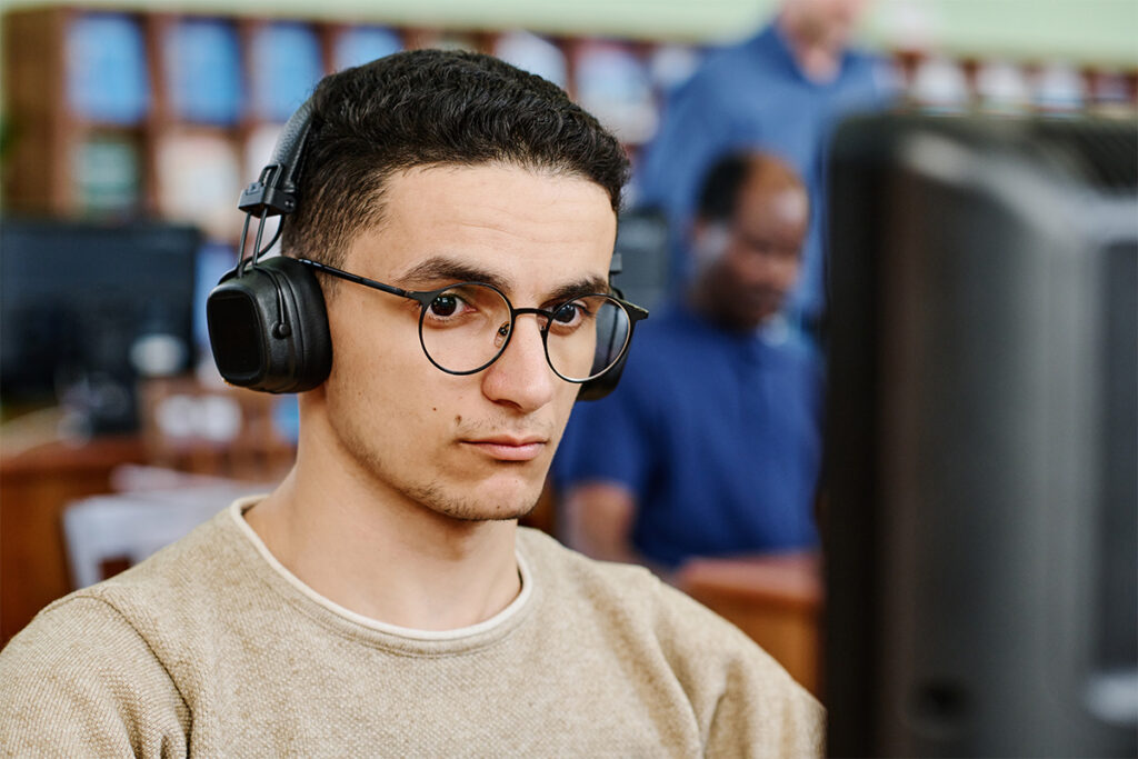 Man sitting in a classroom with headphones on