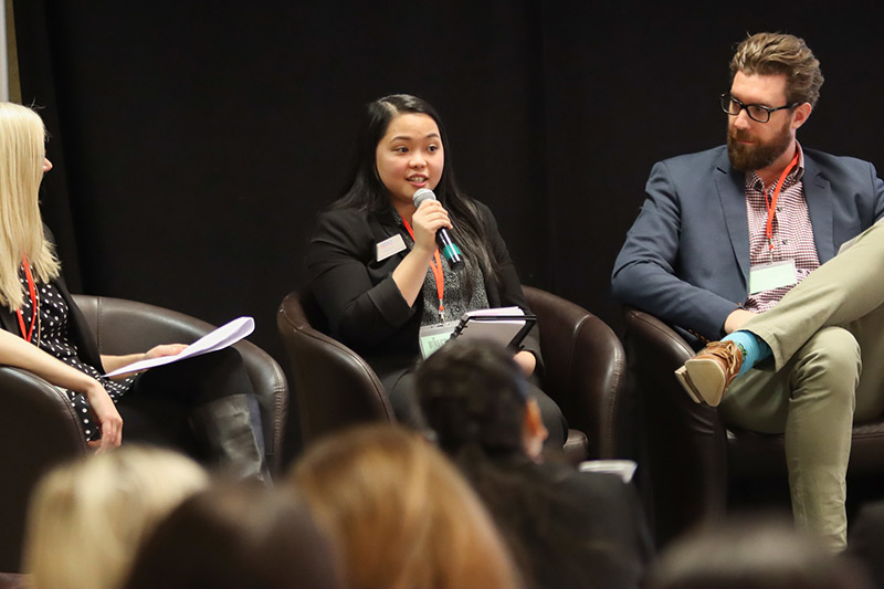 Three people on a stage as part of a panel