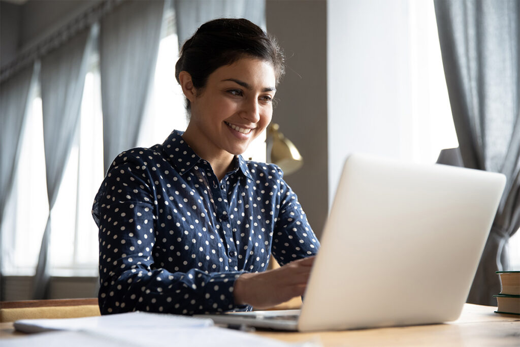 Smiling woman working on a laptop