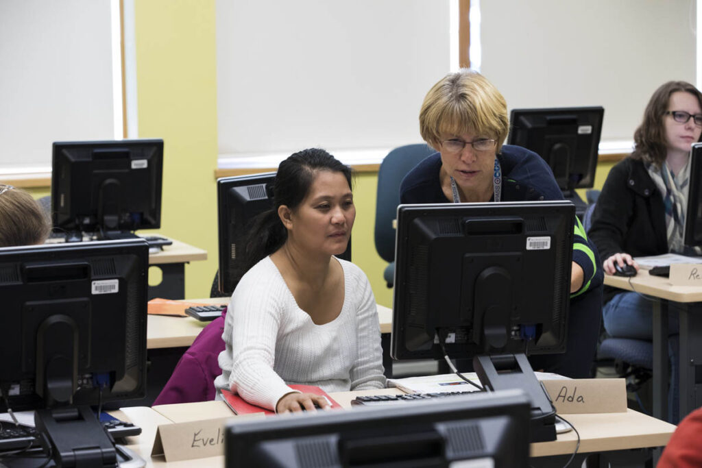 Instructor showing a student something in a computer lab