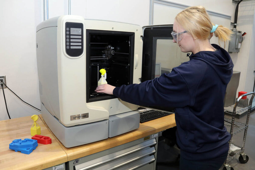 Student using a 3D printer in a lab