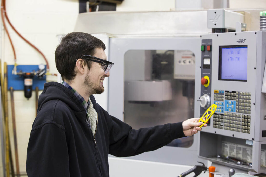 Student using a CNC machine in a lab