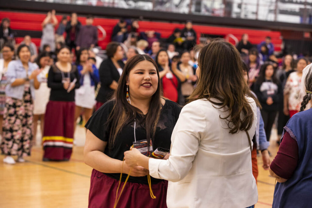 Student and administrator talking at the Indigenous Graduation Pow Wow
