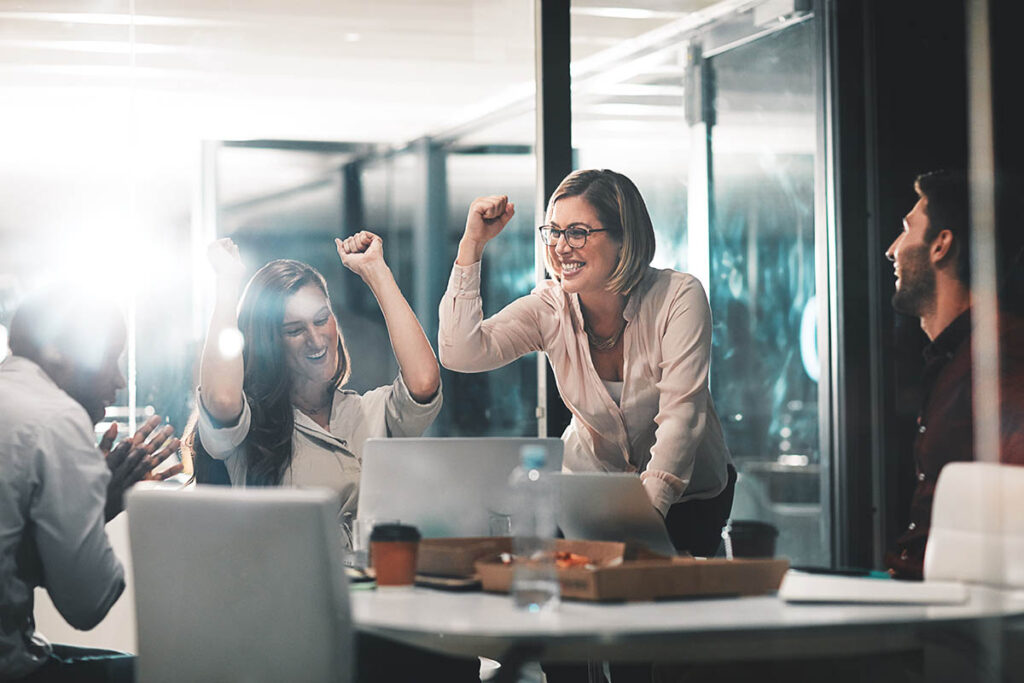 Group of colleagues smiling and fist pumping