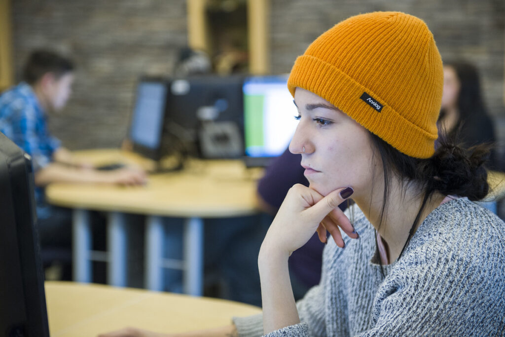 Person with toque sitting in a computer lab