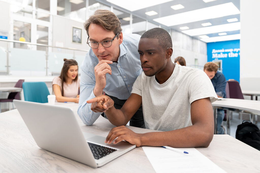 Instructor and student working on a laptop