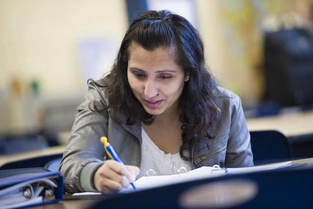 Woman taking notes in a classroom