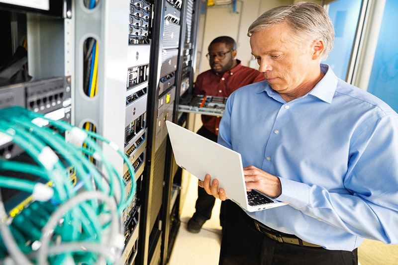 Man holding laptop in networking room