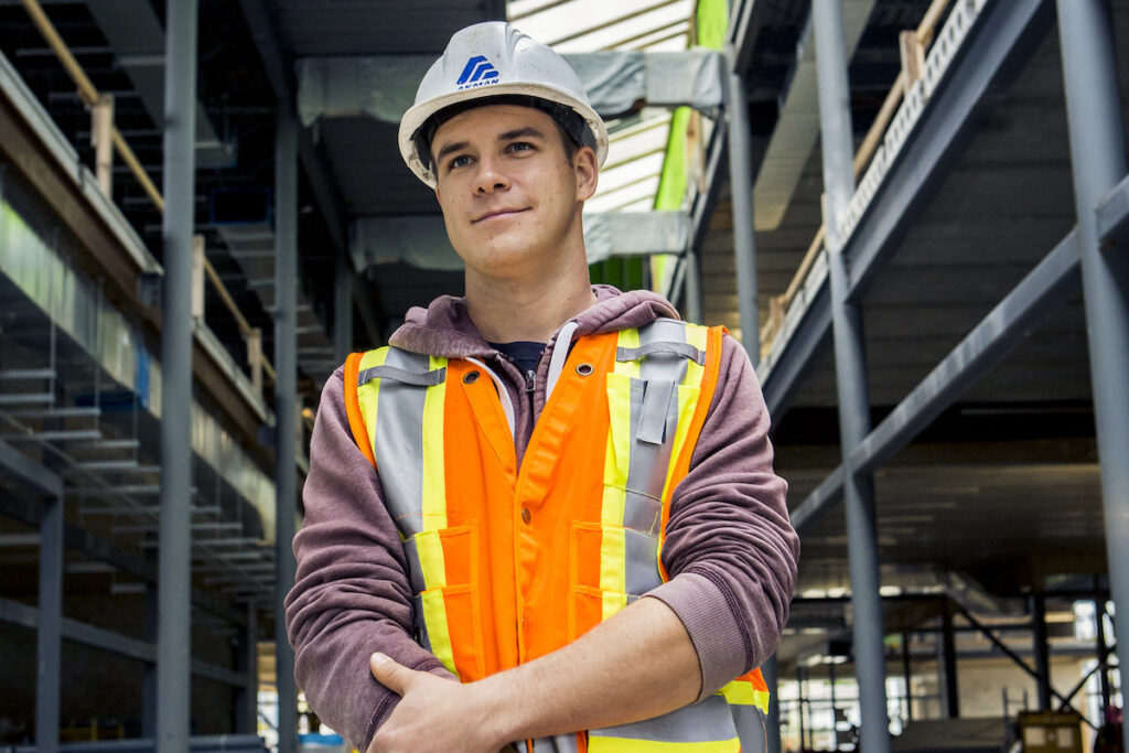 Smiling man in hard hat and safety vest at a construction site