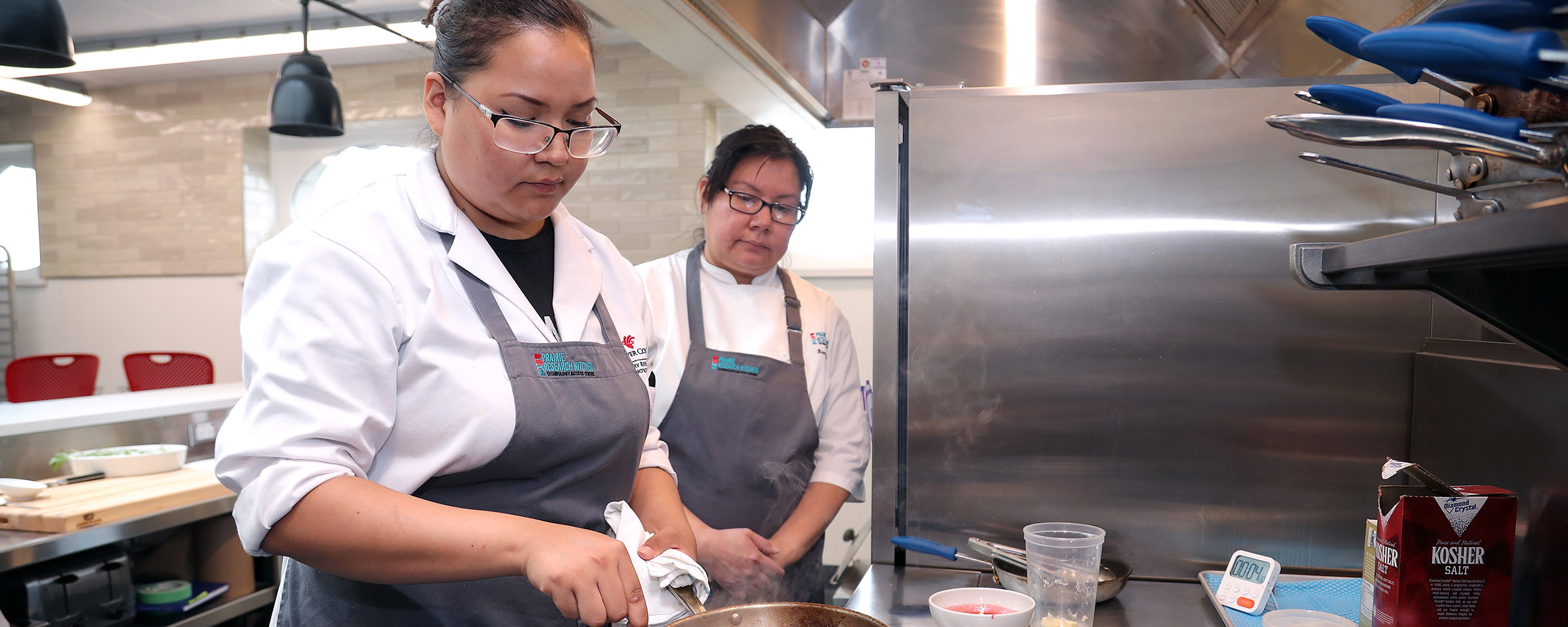 Two culinary students working in a kitchen lab