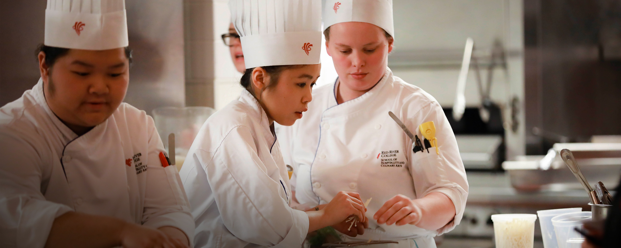 Culinary students preparing food in a commercial kitchen